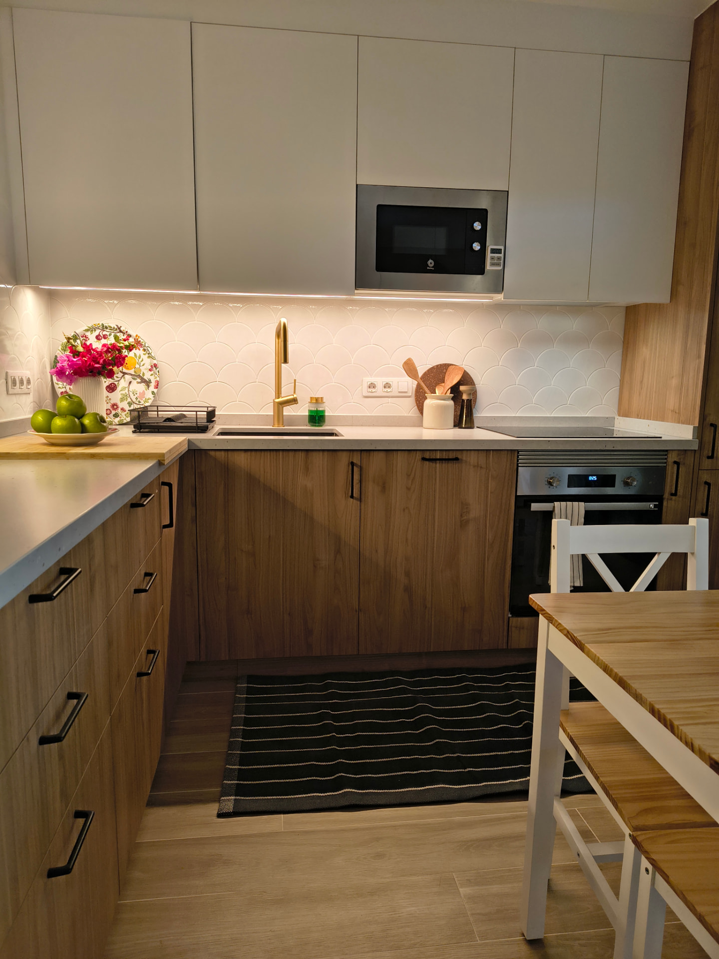 Kitchen lit by natural light with warm light points over the countertop