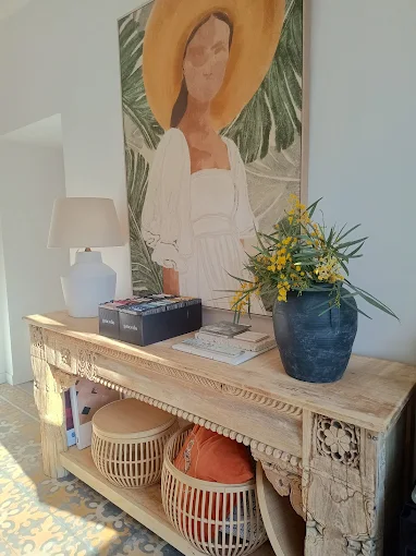 Geschnitzte Holzkonsole mit Lampe, Weidenkorb und Vase mit Mimosen in einem von Coconut Interior Design gestalteten Interieur