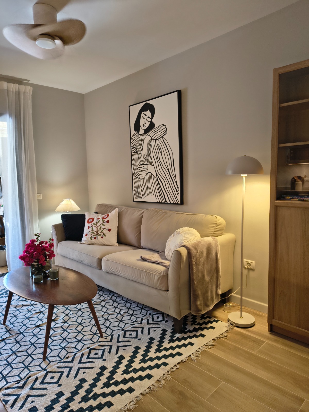 Wohnzimmer mit Deckenventilator und maßgefertigten Möbeln