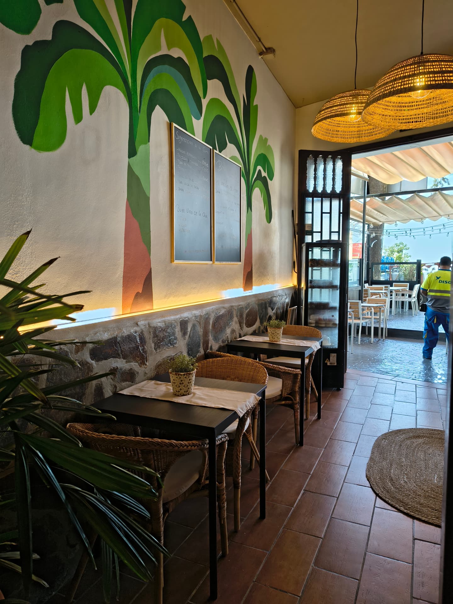 Restaurantraum mit handgemaltem Wandbild, Steinsockel und Faserlampen