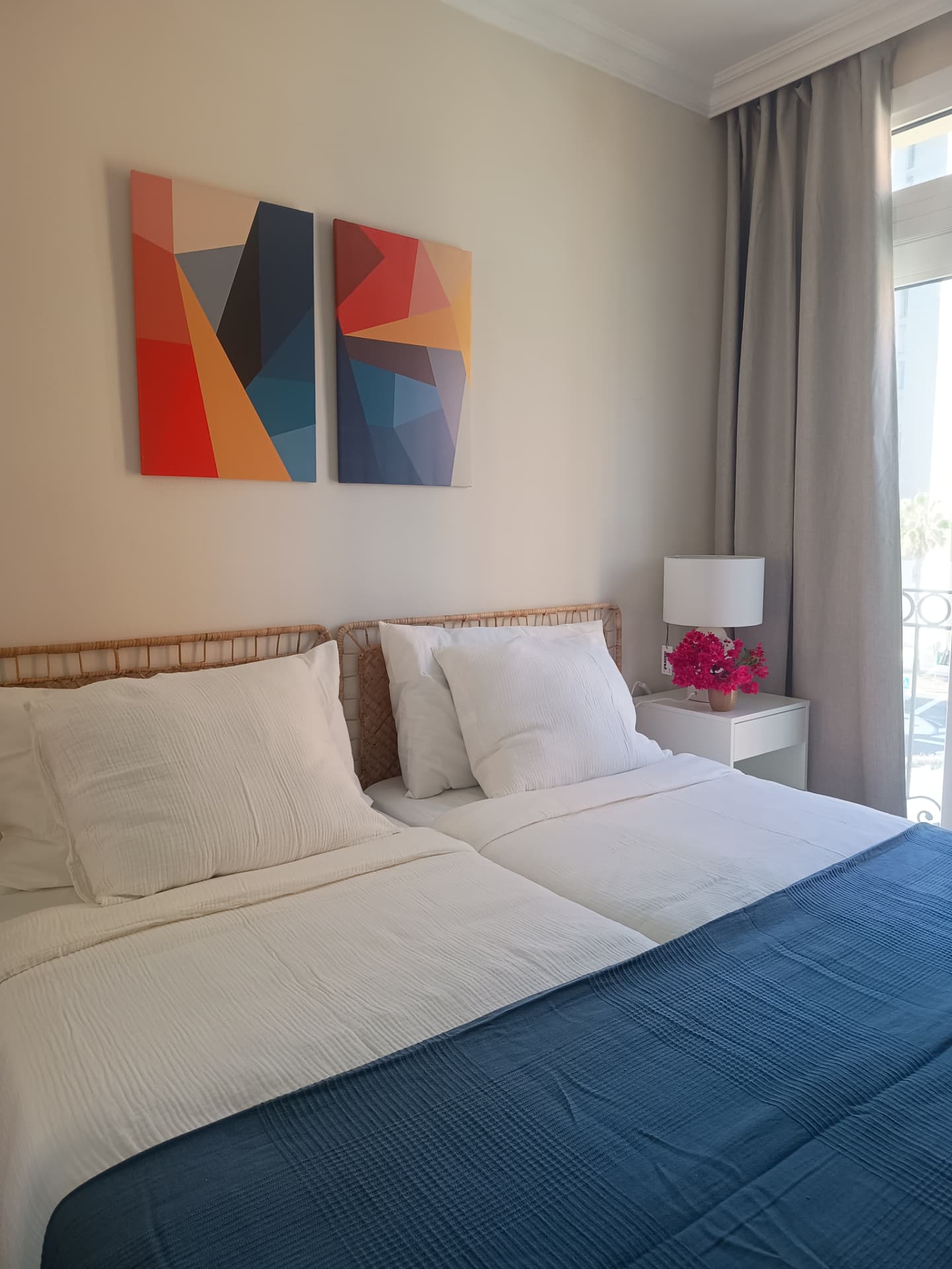 Schlafzimmer mit geometrischem Kunstdruck und blauen Textilien