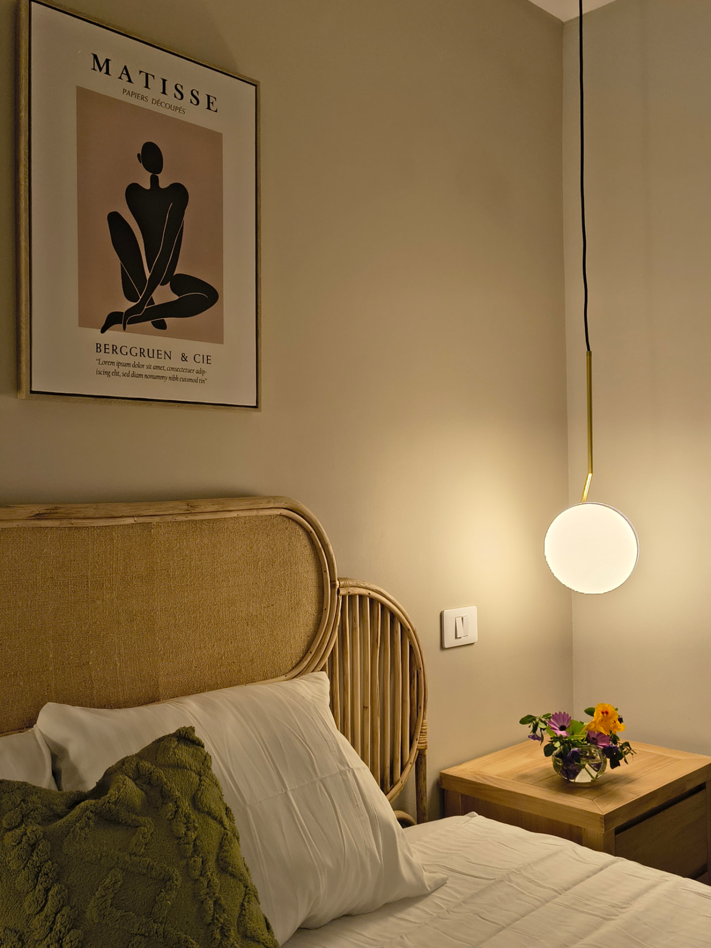Schlafzimmerecke mit Rattan-Kopfteil, Matisse-Kunstdruck und Hängelampe
